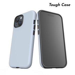 Puede incluir: Dos fundas de tel&eacute;fono azul claro con bordes negros. Una funda se muestra desde la parte trasera, mostrando las lentes de la c&aacute;mara. La otra funda se muestra desde el frente, mostrando la pantalla. El texto "Tough Case" est&aacute; en la esquina superior derecha.