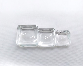 Puede incluir: Tres soportes de exhibición de vidrio transparente de diferentes tamaños, perfectos para mostrar artículos pequeños como joyas o cristales.
