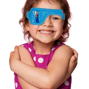 May include: A young girl wearing a pink polka dot dress with a blue eye patch featuring an embroidered image of Elsa and Anna from the movie Frozen.