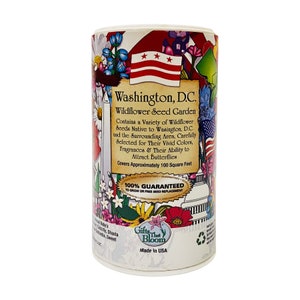 May include: A white cylindrical container with a colorful illustration of wildflowers and the Washington, D.C. flag. The container is labeled "Washington, D.C. Wildflower Seed Garden" and includes the text "100% Guaranteed to Grow or Free Seed Replacement".