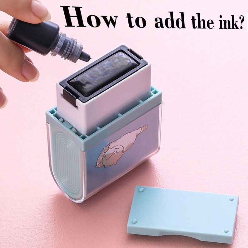 May include: A blue and white stamp with a cartoon cat design. The stamp is open and a small bottle of black ink is being used to refill the ink pad.