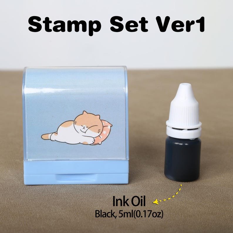 May include: A blue and white stamp featuring a cartoon cat sleeping on a pillow. The stamp is labelled "Stamp Set Ver1". A small bottle of black ink is included, labelled "Ink Oil Black, 5ml (0.17oz)".