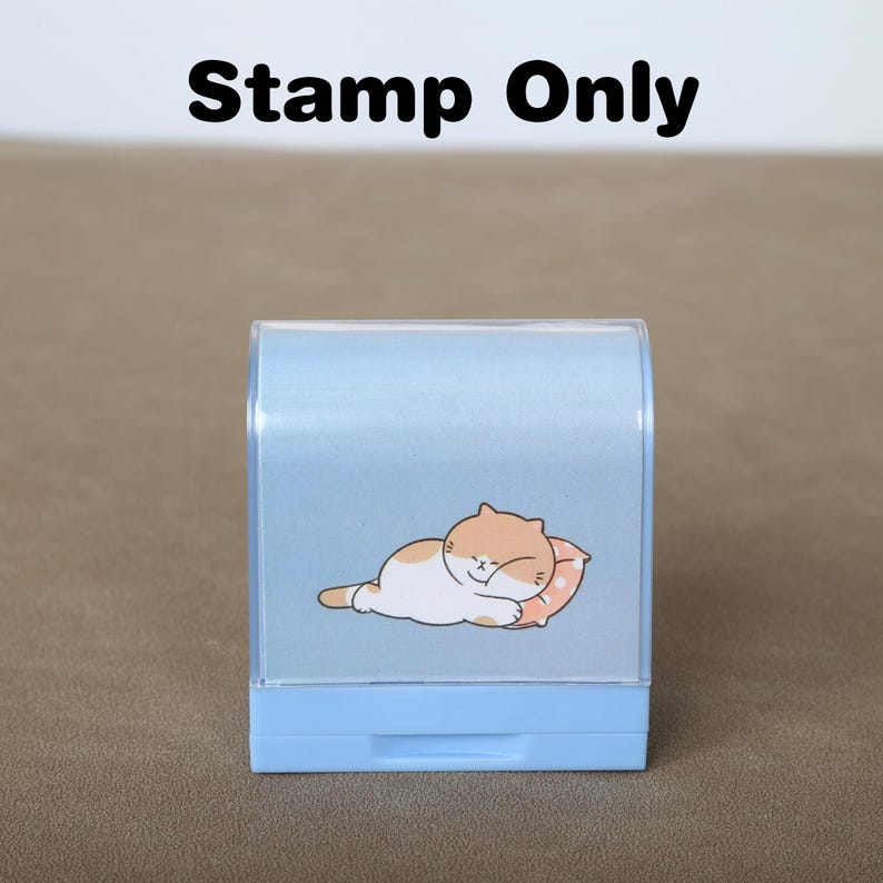 May include: A light blue plastic stamp featuring a cartoon cat sleeping on a pillow. The stamp reads "Stamp Only" at the top.