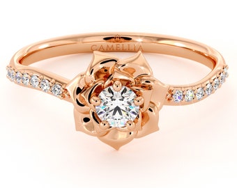 May include: A rose gold engagement ring with a single round diamond set in a rose-shaped setting. The band is adorned with a row of small diamonds.
