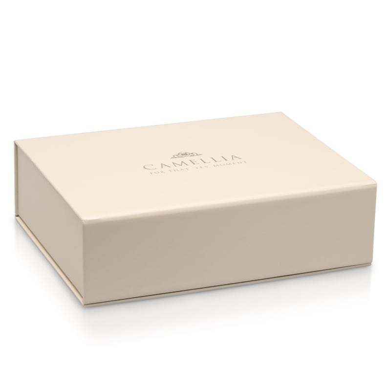 Puede incluir: Una caja de color crema con el texto "Camellia for that yes moment" impreso en la parte superior.