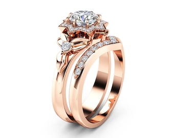 May include: Rose gold engagement ring set featuring a large, round-cut diamond center stone surrounded by smaller diamonds in a floral design. The band includes a row of small diamonds. A second band is included.