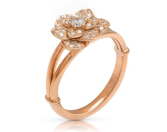 May include: A rose gold ring with a flower-shaped setting adorned with small diamonds. The center of the flower features a larger diamond.