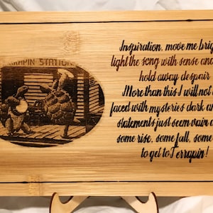 May include: A wooden cutting board with a laser-engraved image of three turtles and the text "MPIN STATION". The board also features an engraved poem: "Inspiration, move me brightly light the song with sense and color. hold away despair More than this I will not ask faced with mysteries dark and vast statements just seem vain at last some rise, some fall, some climb to get to Terrapin!"