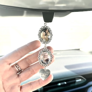 May include: Silver car charm with three photo frames. Two oval frames and a heart-shaped charm are connected. The heart charm has the text "You are always in my heart". The frames hold colour photos.