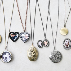 May include: A collection of nine silver and gold locket necklaces with various designs and photos inside. The lockets are round, oval, and heart-shaped.