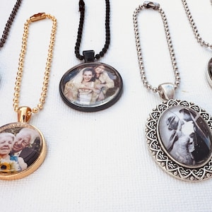 May include: A collection of personalized photo pendant necklaces. The pendants feature oval and round shapes with images of people. The chains are in various colors, including gold, silver, and black.