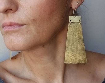 Long statement earrings made of brushed brass