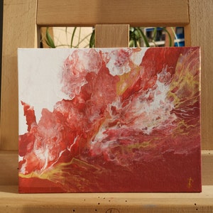 May include: Abstract painting on canvas with red, white, and gold paint. The paint is swirled and layered to create a dynamic and textured effect.