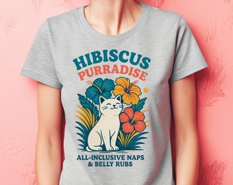 May include: A light grey t-shirt with a cartoon cat design and the words "Hibiscus Purradise." The image includes blue, orange, and red hibiscus flowers and the phrase "All-Inclusive Naps & Belly Rubs."