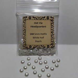 May include: A bag of 144 white half-round 5mm hot fix pearls. The bag has a label that reads "Hot Fix Headquarters 144 5mm Hotfix White Half Pearls".