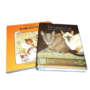 May include: Two hardcover books. One is orange with the title "The Story of Tom Kitte". The other is dark brown with the title "The Literary Cat" and images of two cats. The books are stacked together.