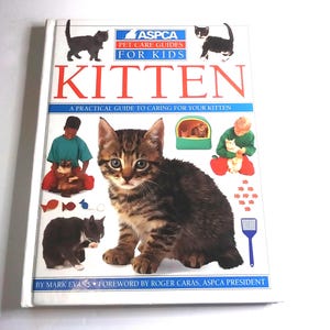 May include: A book titled "Kitten: A Practical Guide to Caring for Your Kitten" by Mark Evans. The cover features a tabby kitten, illustrations of cats, and the ASPCA logo. The book is designed for kids.