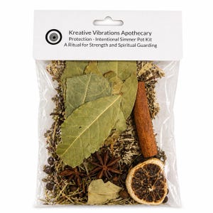 Puede incluir: Una bolsa de plástico transparente llena de hierbas secas, especias y botánicos. Contiene hojas de laurel, anís estrellado, una rama de canela y una rodaja de naranja seca. La etiqueta dice "Kreative Vibrations Apothecary Protection - Intentional Simmer Pot Kit".