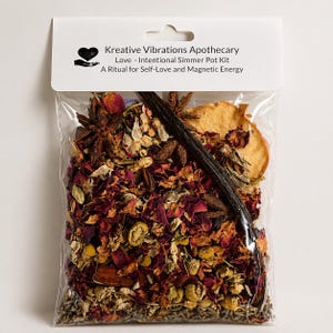 Puede incluir: Una bolsa de plástico transparente llena de un kit para olla a fuego lento. Contiene pétalos de rosa secos, anís estrellado, vainilla y otras hierbas. La etiqueta blanca dice "Kreative Vibrations Apothecary Love - Intentional Simmer Pot Kit".