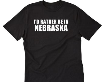May include: Black t-shirt with white text that reads "I'd rather be in Nebraska".