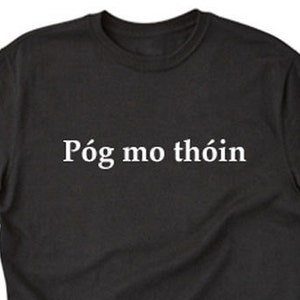 May include: Black t-shirt with white text that reads "Póg mo thóin".