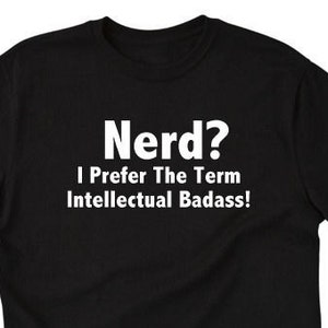May include: Black t-shirt with white text that reads "Nerd? I Prefer The Term Intellectual Badass!" The shirt is a crew neck and appears to be made of a soft material. The text is centered on the front of the shirt.