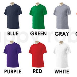 May include: Ten t-shirts in different colours, including black, blue, green, grey, orange, pink, purple, red, white, and yellow.