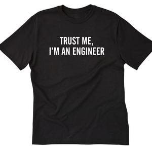 May include: Black t-shirt with the white text "TRUST ME, I'M AN ENGINEER" across the chest. The shirt has short sleeves and a crew neck. The fabric appears to be a soft cotton blend.