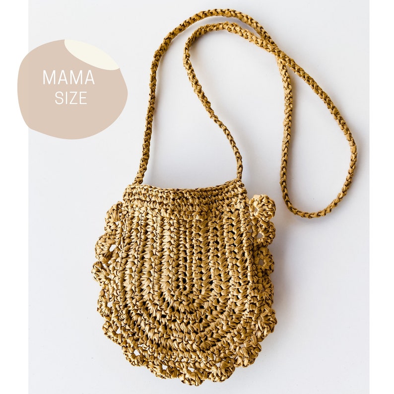 May include: A tan crocheted straw bag with a long strap. The bag has a scalloped edge and is made of a woven material.