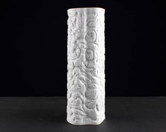 Op de afbeelding: Witte keramische vaas met een reliëfdesign van bloemen en bladeren.