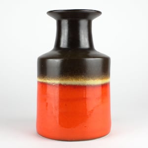 Peut inclure: Un vase en céramique brun et orange avec une large ouverture et un col étroit.