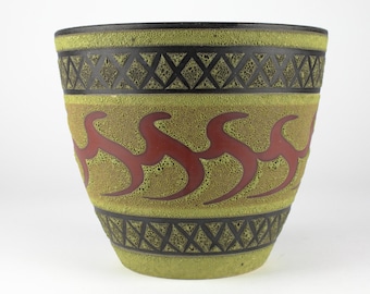 May include: A large, green ceramic planter with a textured surface. It has a black and red geometric design around the middle.