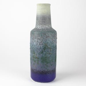 Peut inclure: Un vase en céramique haut et moucheté de bleu, de vert et de blanc. Le vase a une forme arrondie, semblable à une bouteille.