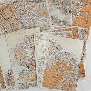 May include: A collection of vintage maps with a sepia-toned color palette. The maps feature detailed geographical information, including coastlines, roads, and place names. The maps are arranged in a layered composition, showcasing their aged appearance.