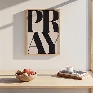 Christian prayer room decor featuring PRAY typography wall art print with a bowl of fruit and some books