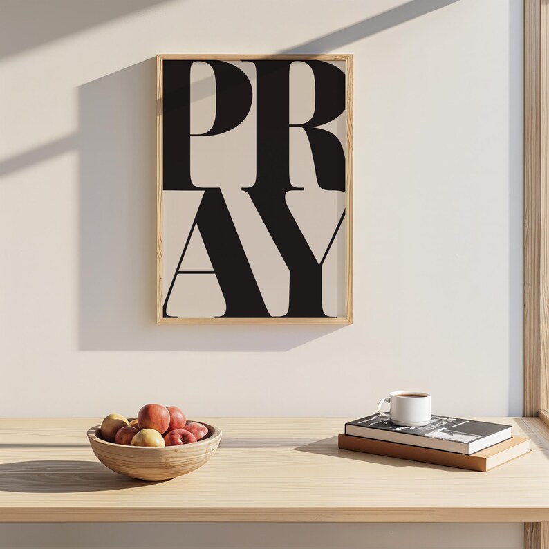 Christian prayer room decor featuring PRAY typography wall art print with a bowl of fruit and some books