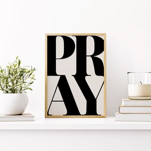 Black and white faith wall art printable displayed in Christian prayer space on a shelf with books, a candle and a plant. Perfect dorm room poster for christian teens, teenagers bedroom artwork.
