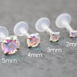 Puede incluir: Cuatro piercings transparentes para labios con gemas redondas e iridiscentes. Tamaños: 2 mm, 3 mm, 4 mm y 5 mm. Cada pendiente tiene una parte trasera plana transparente y un poste transparente.