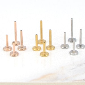 May include: A set of 10 surgical steel body jewelry studs in three colors: gold, rose gold, and silver. The studs are available in different lengths and are ideal for cartilage piercings, helix piercings, and lobe piercings.