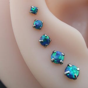 May include: A set of three ceramic mugs with a speckled, matte finish. The mugs are in shades of cream, light gray, and dark gray. Each mug has a simple, minimalist design, perfect for coffee or tea.