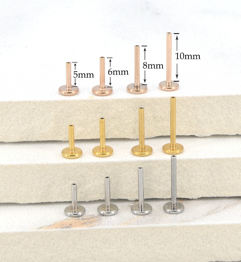 May include: A set of nine surgical steel body jewelry pieces in three different colors: gold, rose gold, and silver. The pieces are different lengths, ranging from 5mm to 10mm. The jewelry is displayed on a white surface.
