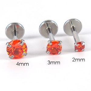 May include: Three silver-colored stud earrings with vibrant orange gemstones. The earrings are displayed in sizes 4mm, 3mm, and 2mm, showcasing the variation in gemstone size. The gemstones are set in a four-prong setting.