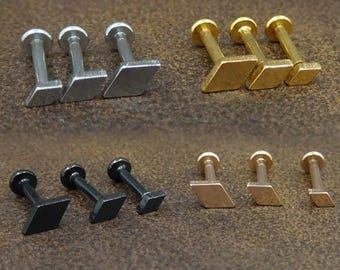 Puede incluir: Tres juegos de tres pendientes de botón en forma de diamante en plata, oro y negro.