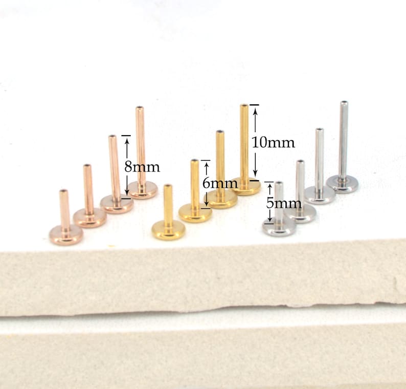 May include: A set of 9 gold and silver body jewelry studs in three different lengths: 5mm, 6mm, and 8mm. The studs are made of surgical steel and are available in a variety of colors.
