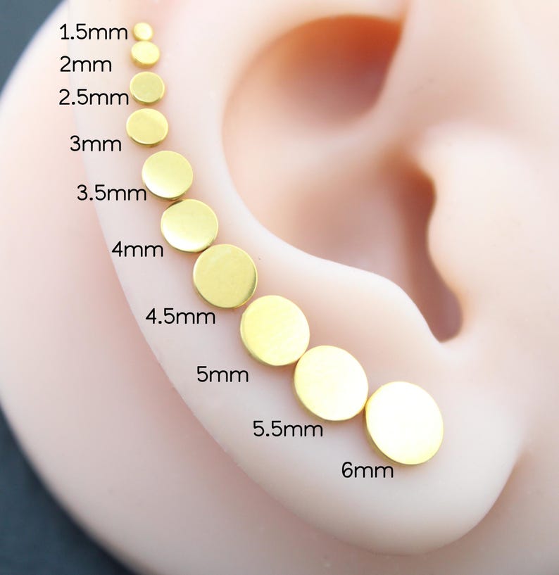 May include: A series of ten gold-colored circular stud earrings arranged in a curved line, ranging in size from 1.5mm to 6mm. Each earring is labeled with its specific diameter measurement, starting from 1.5mm and increasing to 6mm.