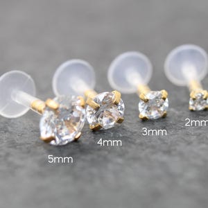 May include: Four clear, round-cut crystal labret studs with gold-colored settings and posts. Sizes are 2mm, 3mm, 4mm, and 5mm. Each stud has a clear, flat backing.