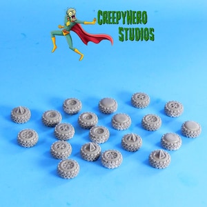 May include: A collection of small, gray model tires with detailed tread patterns. The background is a light blue with the text "CREEPYHERO STUDIOS" and a cartoon character.