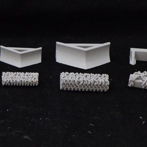 May include: A set of 3D printed model train track pieces, including straight track, curved track, and a crossing. The pieces are made of white plastic and are designed to be used with model trains.