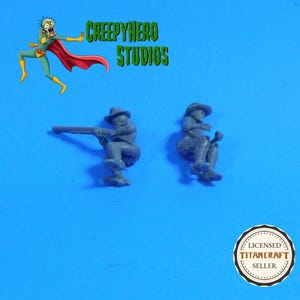 May include: Two gray miniature cowboy figurines, one aiming a rifle and the other holding a saddle. The image includes the text "CREEPYHERO STUDIOS" and a "LICENSED TITANCRAFT SELLER" seal on a blue background.