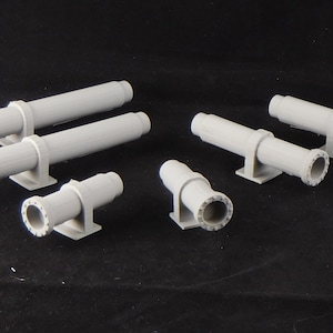 May include: A set of seven gray plastic model pipes with flanges. The pipes are of various sizes and shapes, including straight and angled pieces. The pipes are designed for use in model railroading or other model building projects.